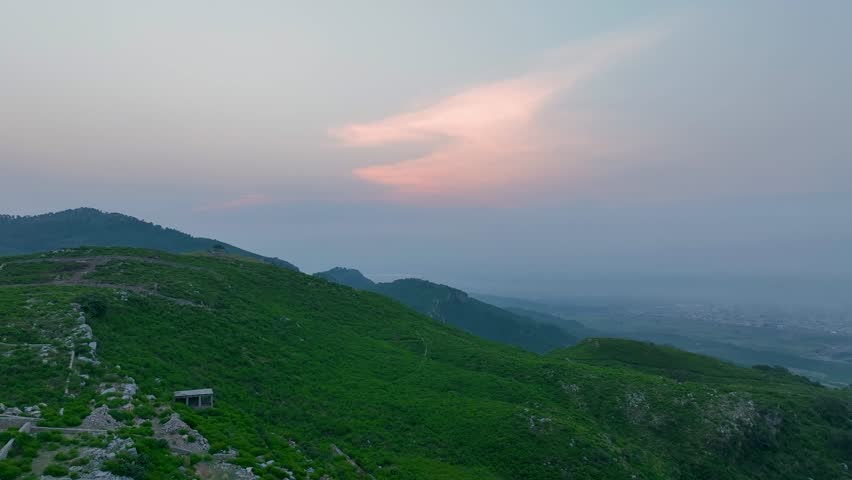 Drone view of Islamabad’s Margalla Hills at sunrise, golden light over green forests and hills, a breathtaking natural landscape perfect for travel, nature, scenic visuals, and tourism.
