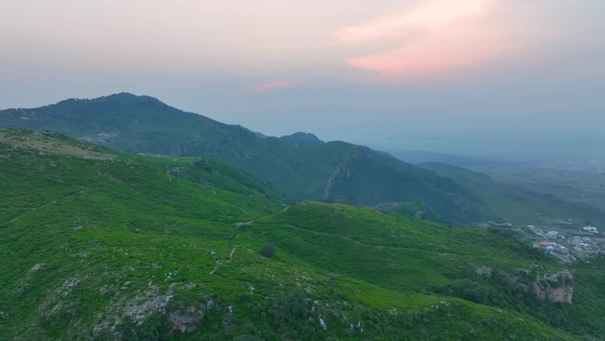 Drone view of Islamabad’s Margalla Hills at sunrise, golden light over green forests and hills, a breathtaking natural landscape perfect for travel, nature, scenic visuals, and tourism.
