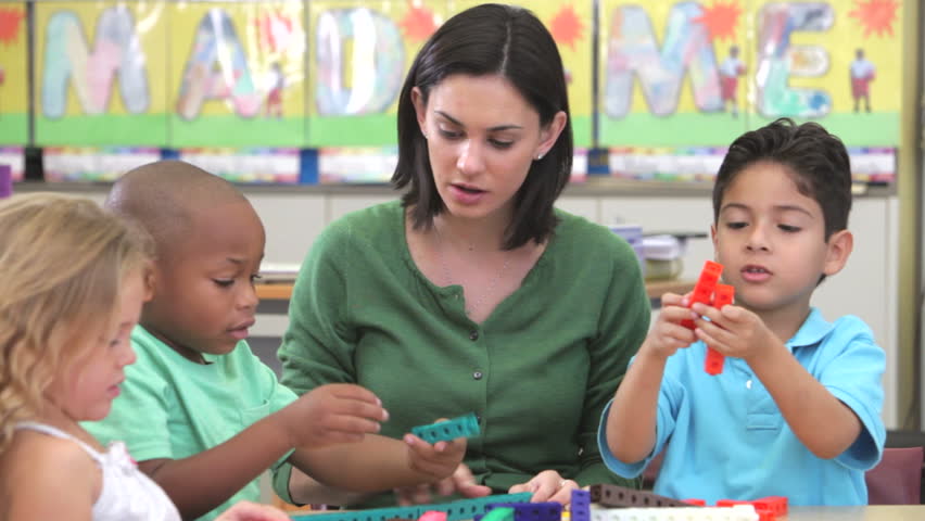 Group of students sitting at table with teacher using plastic construction set.Shot on Canon 5d Mk2 with a frame rate of 30fps