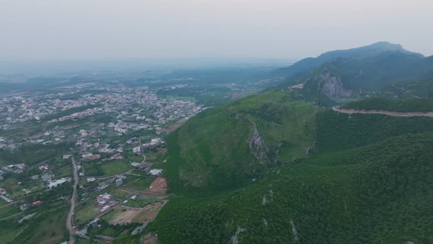Drone view of Islamabad’s Margalla Hills at sunrise, golden light over green forests and hills, a breathtaking natural landscape perfect for travel, nature, scenic visuals, and tourism.
