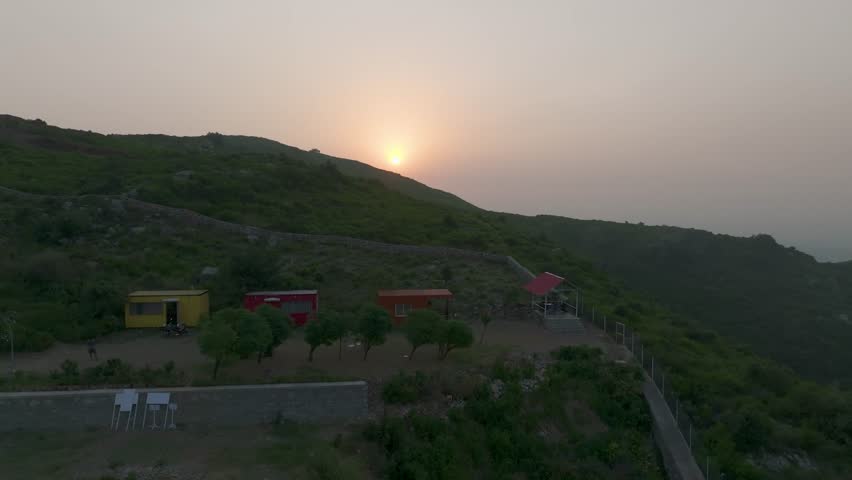 Drone view of Islamabad’s Margalla Hills at sunrise, golden light over green forests and hills, a breathtaking natural landscape perfect for travel, nature, scenic visuals, and tourism.
