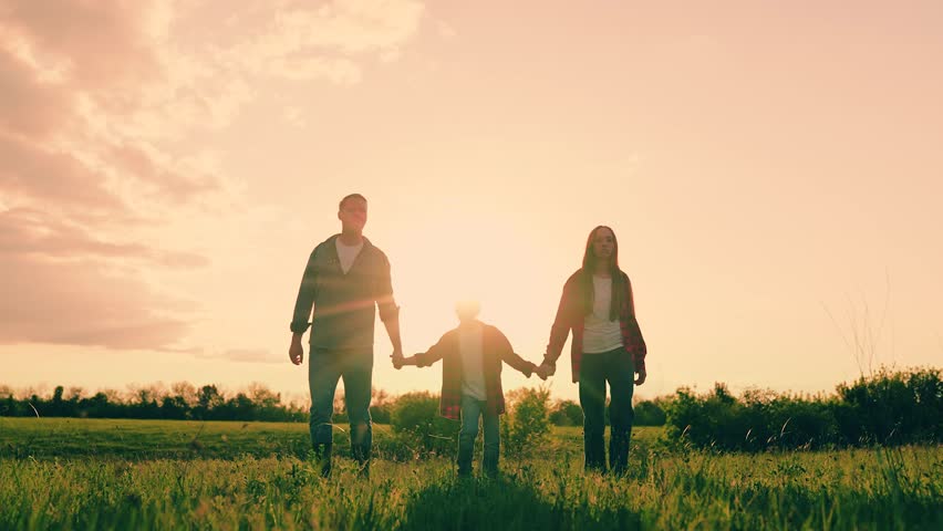 Father, daughter son playing on natural grass meadow enjoy freedom together. Parent children boy girl playing in meadow. Happy family running flying holding hands at sunset sunny field slow motion.