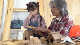 Asia retirement carpenter man and cheerful granddaughter enjoy create birdhouse toy in carpentry studio, aged people teaching woodwork skill to kids, family hobby lifestyle parenthood togetherness - Powered by Shutterstock - Get 15% off with code: PIKWIZARD15