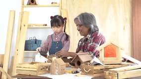Asia retirement carpenter man and cheerful granddaughter enjoy create birdhouse toy in carpentry studio, aged people teaching woodwork skill to kids, family hobby lifestyle parenthood togetherness - Powered by Shutterstock - Get 15% off with code: PIKWIZARD15