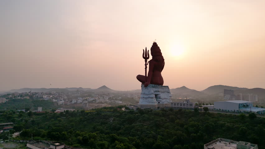 Majestic aerial view of the towering Lord Shiva statue surrounded by serene hills.