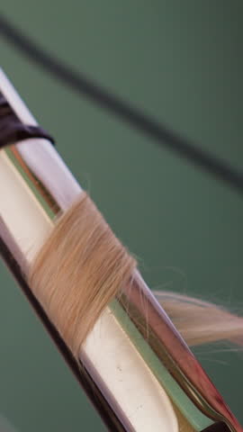 Hairdresser uses hot curling iron to make stylish lock to female client in contemporary professional beauty salon extreme close view slow motion