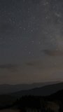 Time lapse of Starry night sky over mountains, Clear starry night sky over silhouetted mountains in peaceful wilderness. Vertical footage - Powered by Shutterstock - Get 15% off with code: PIKWIZARD15