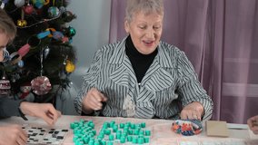 An elderly old woman pensioner plays Bingo. A grandmother with her family plays board games near Christmas tree at home. Lotto. Time together - Powered by Shutterstock - Get 15% off with code: PIKWIZARD15