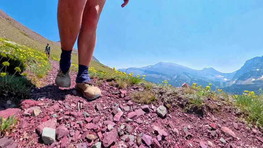 Womans Legs Hiking with Man Behind in Glacier National Park