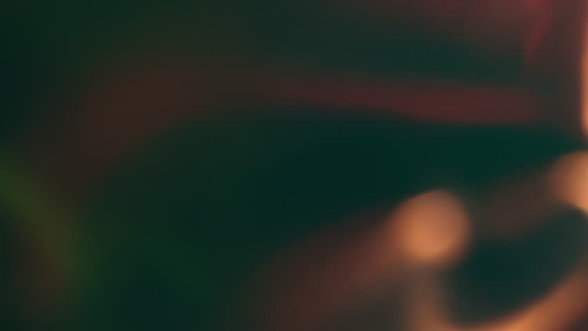 Defocused glow. Blur light. Sparkling lens flare golden color black color shining glare on dark black art abstract background.