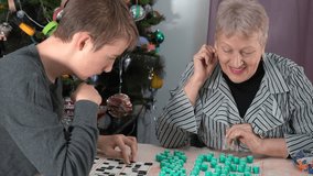 Elderly woman pensioner plays Bingo. A grandmother with her grandson play board game at home. Lotto. Time together. They clap their hands joyfully and laugh. They greet and congratulate. - Powered by Shutterstock - Get 15% off with code: PIKWIZARD15