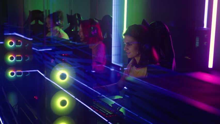Young Girls are having fun gaming at the computer club. Girls are winning the game and having fun with each other. Girls are celebrating the game win by giving high fives and funny smiles.