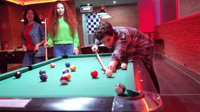 Young friends enjoying competitive pool game in vintage pub, illuminated by warm red lights, sharing joyful moments of camaraderie and leisure - Powered by Shutterstock - Get 15% off with code: PIKWIZARD15