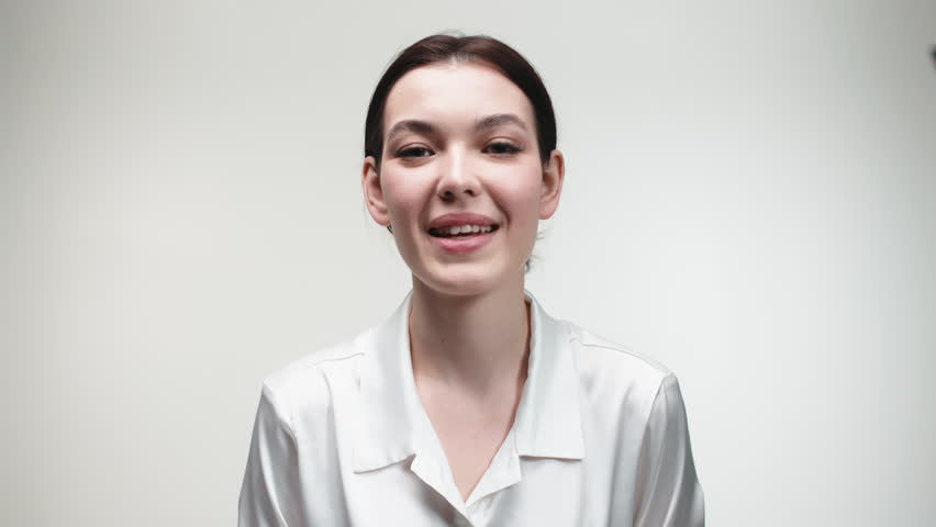 Close-up of a happy young woman with a smile touching her face. Concept of cosmetic skin care treatments.