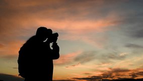 Travel woman photographer shooting photo video dramatic sunset sky use camera closeup. Female backpacker silhouette art photographing wanderlust nature landscape picturesque sunrise cloudscape. Hiking - Powered by Shutterstock - Get 15% off with code: PIKWIZARD15
