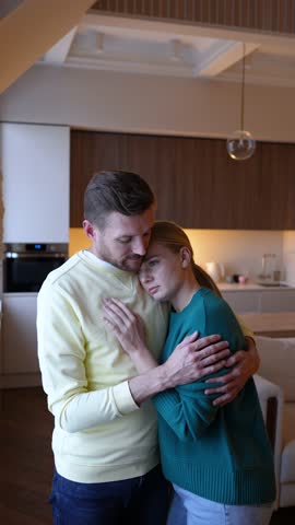 Sad depressed woman crying in husband embrace hug, sorrowful grief for young couple. Consoling husband comforting, offering emotional support, strong connection in family, healthy relationship