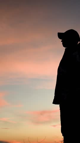 Woman traveler with camera, backpack, Silhouette. Photographer taking beautiful photos of nature at sunset. Woman photographer taking photo with camera beautiful landscape at dawn against sky. Travel