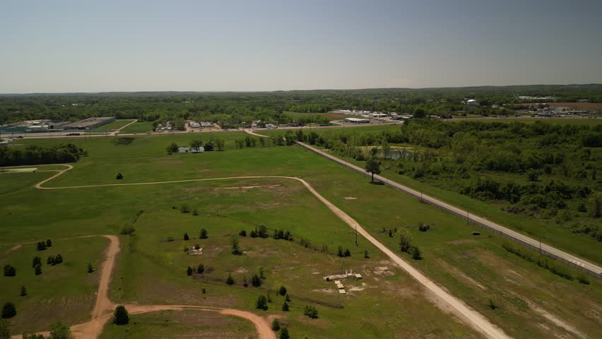Aerial of rural town in Alabama with grassy fields in spring