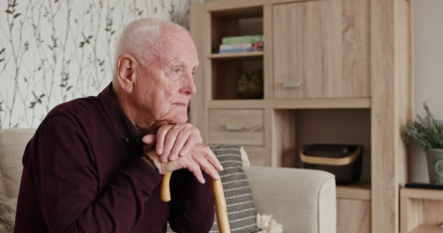Senior man, thinking and cane in home on sofa with alzheimer, dementia or lonely in retirement. Elderly, depression or old person with disability in house and mental health with stress or anxiety