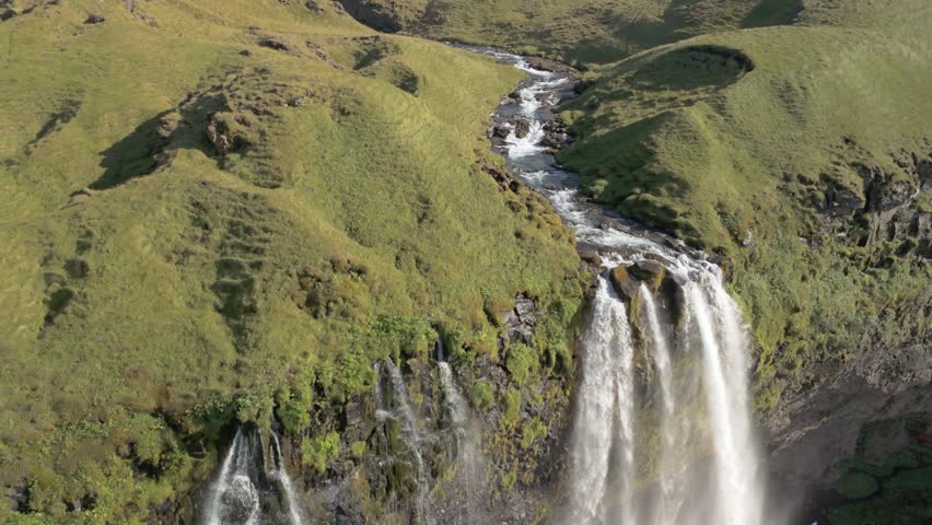 Stunning Aerial View of Iceland Majestic Landscape, Featuring a Flowing River and Dramatic Canyon, All Bathed in the Warm Glow of a Sunny Summer Day. Perfect for Nature and Adventure Content.