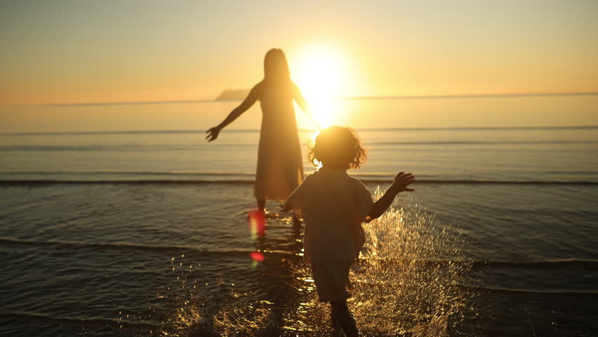 A heartwarming moment as a child runs joyfully into their mother's arms by the sea at sunset. Pure love, trust, and connection captured in golden light and gentle ocean waves.