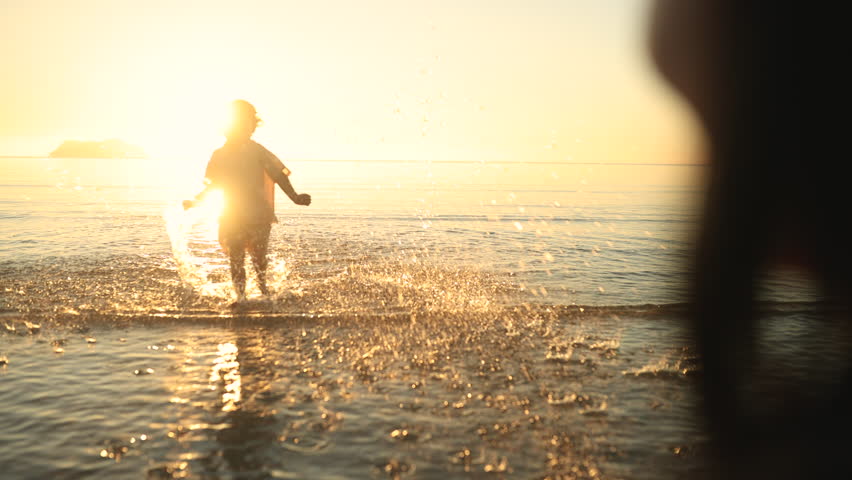 A heartwarming moment as a child runs joyfully into their mother's arms by the sea at sunset. Pure love, trust, and connection captured in golden light and gentle ocean waves.