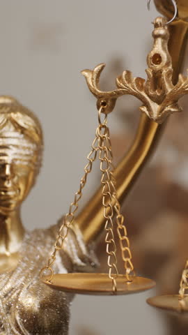 Golden scales of Justice Statue swaying on abstract background, vertical video