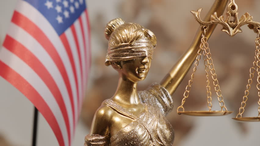 Themis statue with scales of justice with United States of America flag on background of world map