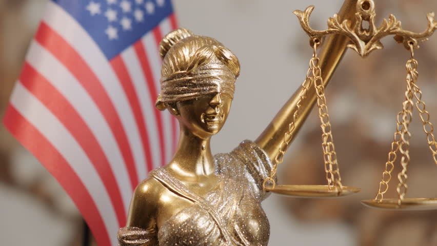 Themis statue with scales of justice with United States of America flag on background of world map