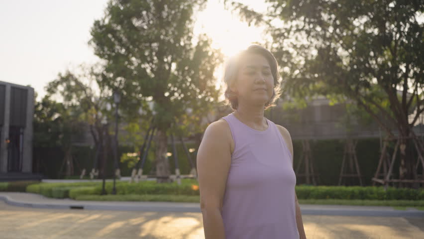 Asia adult aged people middle age mindful happy old woman yoga body pose zen calm stress relief outdoor nature public park sun light self love relax elder aging life asian female mental health care.