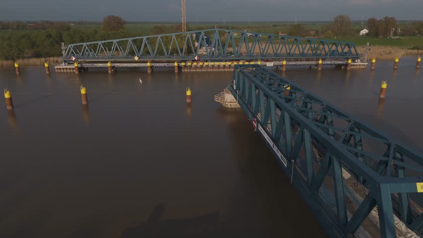 Aerial shot of the new Friesenbrücke railway project near Leer, Germany, at sunset. Massive infrastructure site near Dutch border, crossing the Ems River. Bridge and construction site in golden light.