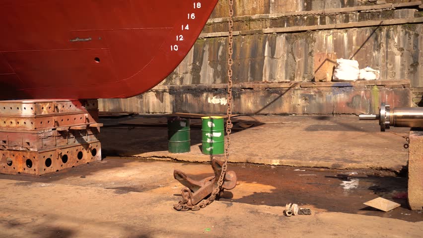 Anchor of ship. Heaving up anchor in dry dock. Vessel ashore on ship repairing yard. Anchor Installation.  