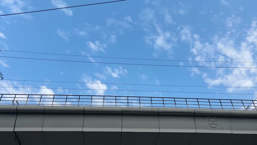 A low angle footage of the subway train moving at the Guru Dronacharya metro station on a sunny day in Gurgaon city, New Delhi, India