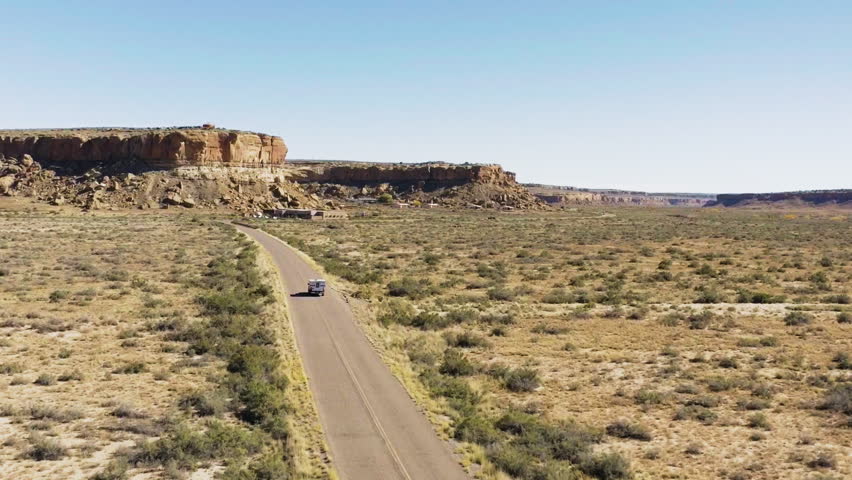 Chaco Canyon Road with Solitary Car in Arid New Mexico Landscape
