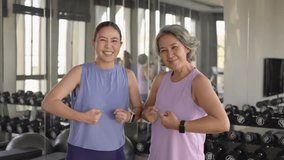 Young adult child and middle age old mum smile look at camera gym workout body weight picking up arm lift dumbbell. Health care older mom asia elder people happy protect aging life sport build muscle. - Powered by Shutterstock - Get 15% off with code: PIKWIZARD15