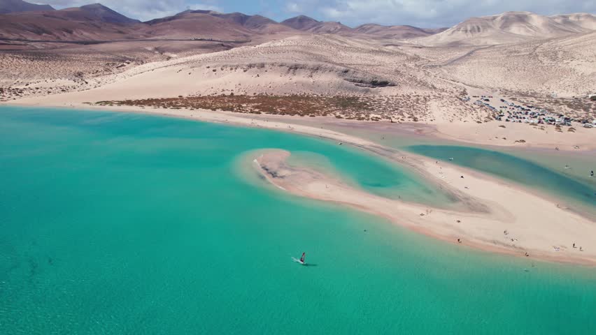 Turquoise waters, sandbars, lagoons, and wide open beaches, and mountains showcase the stunning natural beauty of Sotavento beach in Fuerteventura, Canary Islands by aeiral 4k drone