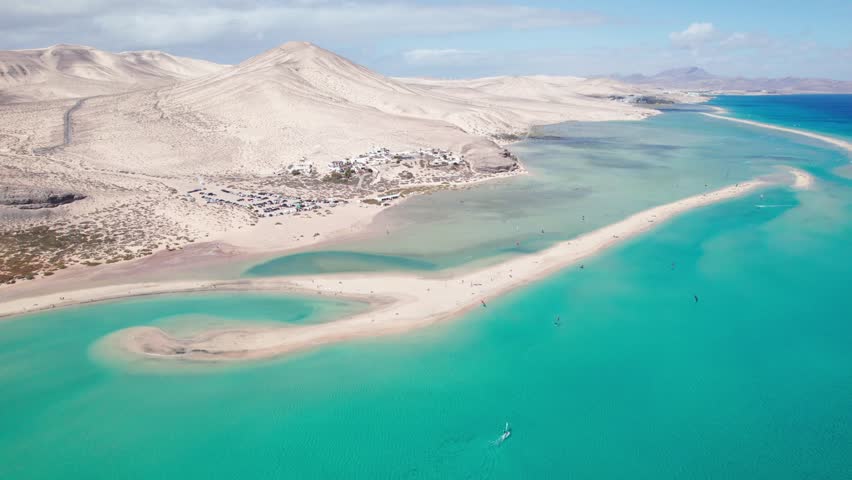 Turquoise waters, sandbars, lagoons, and wide open beaches, and mountains showcase the stunning natural beauty of Sotavento beach in Fuerteventura, Canary Islands by aeiral distant 4k drone