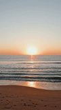 Vertical video golden sunrise over calm sea and sandy beach. Soft light of dawn. Tranquil morning seascape. Coastal scene. Sun rising above ocean horizon. Warm golden light. Travel - Powered by Shutterstock - Get 15% off with code: PIKWIZARD15