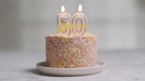 studio shot birthday cake covered with decorations and candle celebrating fiftieth birthday being blown out stock video - Powered by Shutterstock - Get 15% off with code: PIKWIZARD15
