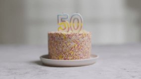 studio shot birthday cake covered with decorations and candle celebrating fiftieth birthday being lit stock video - Powered by Shutterstock - Get 15% off with code: PIKWIZARD15