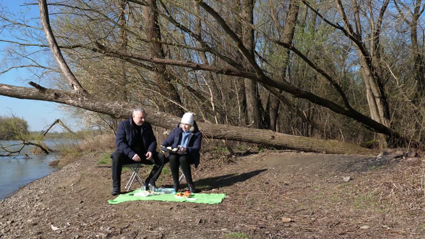 A man and a woman had a picnic on the riverbank.
