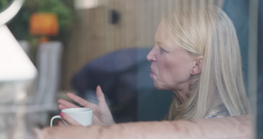 Coffee cup, window and face of woman speaking, talking and share weekend story, gossip or news. Living room discussion, transparent glass and morning person relax, social and home conversation chat