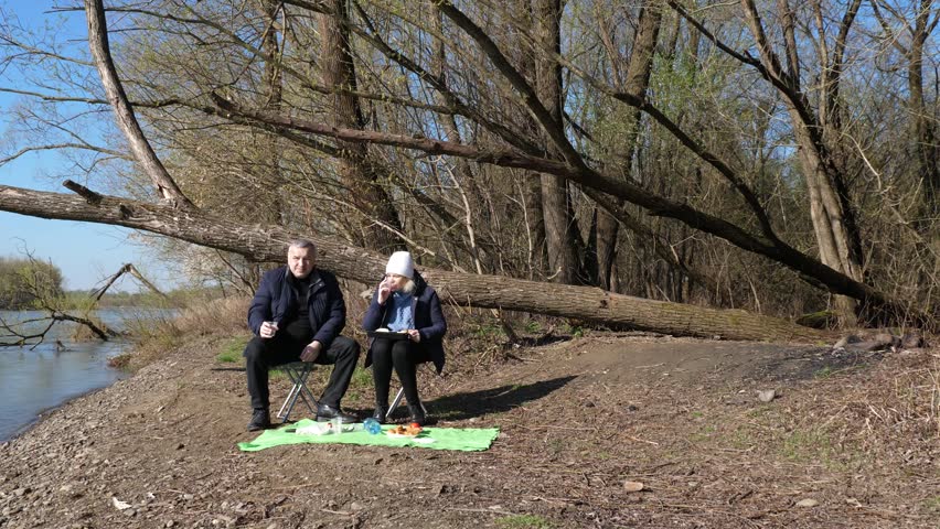 A man and a woman had a picnic on the riverbank.