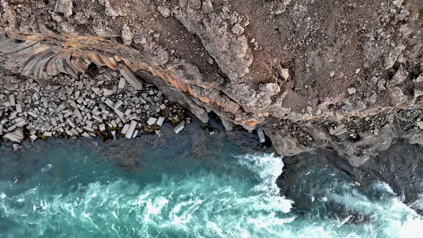 Drone circling rock formations at the Aldeyjarfoss rapids, spring day in Iceland