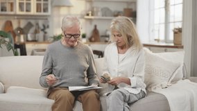 Elderly man and woman counting money and spreading family budget, portrait. Aged people at home, housewife putting dollars on utility bills, paying credits, accounting finance, rich or poor people - Powered by Shutterstock - Get 15% off with code: PIKWIZARD15