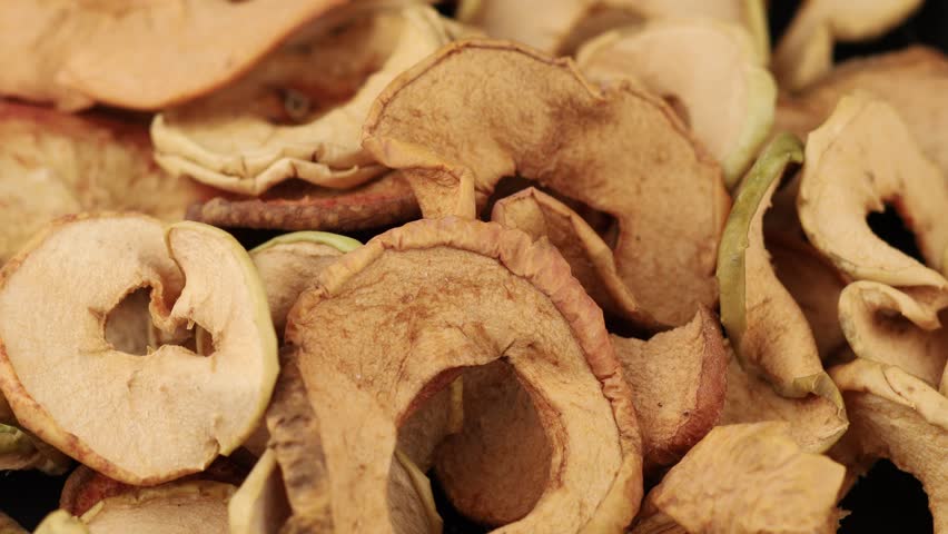Close-up view of dried apple slices capturing their texture and natural hues, highlighting the drying process and food preservation.