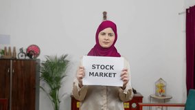 Muslim Woman in Hijab Scarf standing with Stock Market Poster - Powered by Shutterstock - Get 15% off with code: PIKWIZARD15