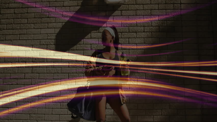 Woman drinking water and checking fitness app on phone against brick wall, showing animated streaks. Dynamic, vibrant, energetic, urban, casual, lifestyle, modern