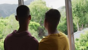 Two men standing by sliding door, watching garden while showing animated red hearts in tech demo. Romantics, affection, connection, nature, outdoor, intimate, vibrant - Powered by Shutterstock - Get 15% off with code: PIKWIZARD15