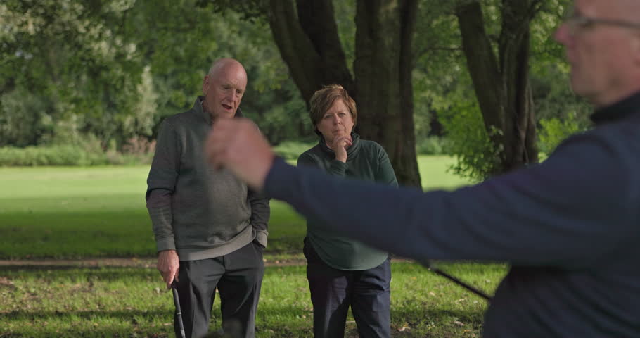 Fitness, talking and a senior friends on a golf course for help or to explain a shot technique to a player. Retirement, hobby or golfing with an elderly man and woman speaking outdoor on a green